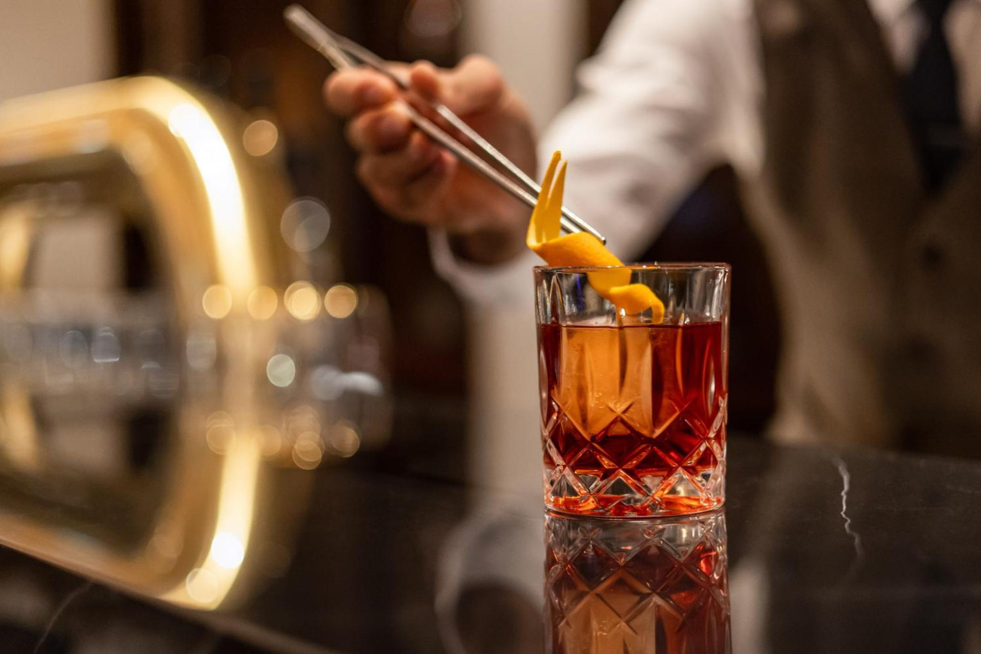 Hotel Intercontinental Berlin By Ihg Esterno foto A bartender adding a lemon twist to a cocktail